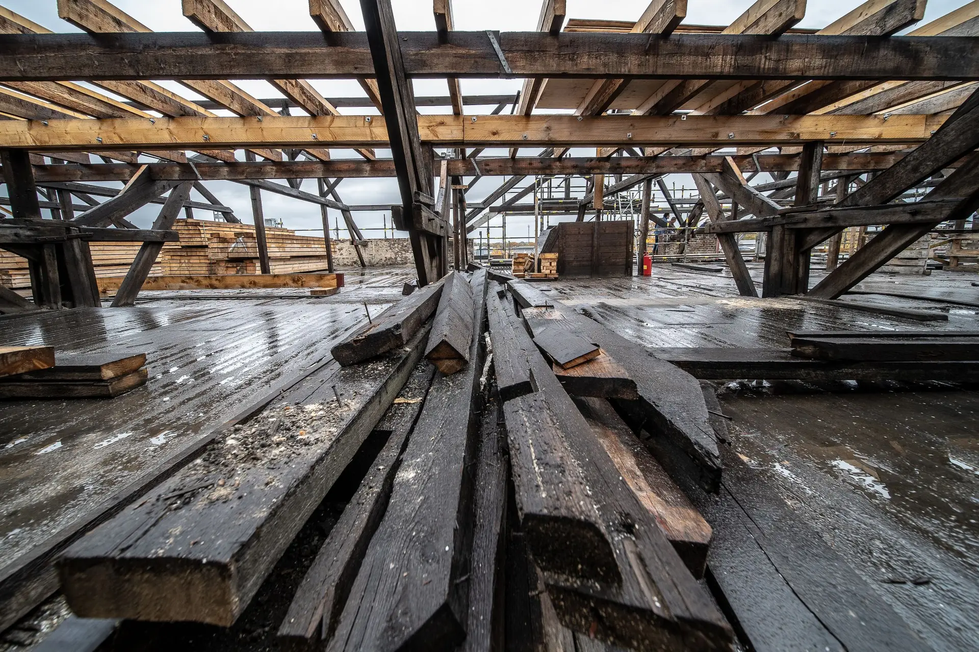 Stacked old timber beams under exposed roof framing