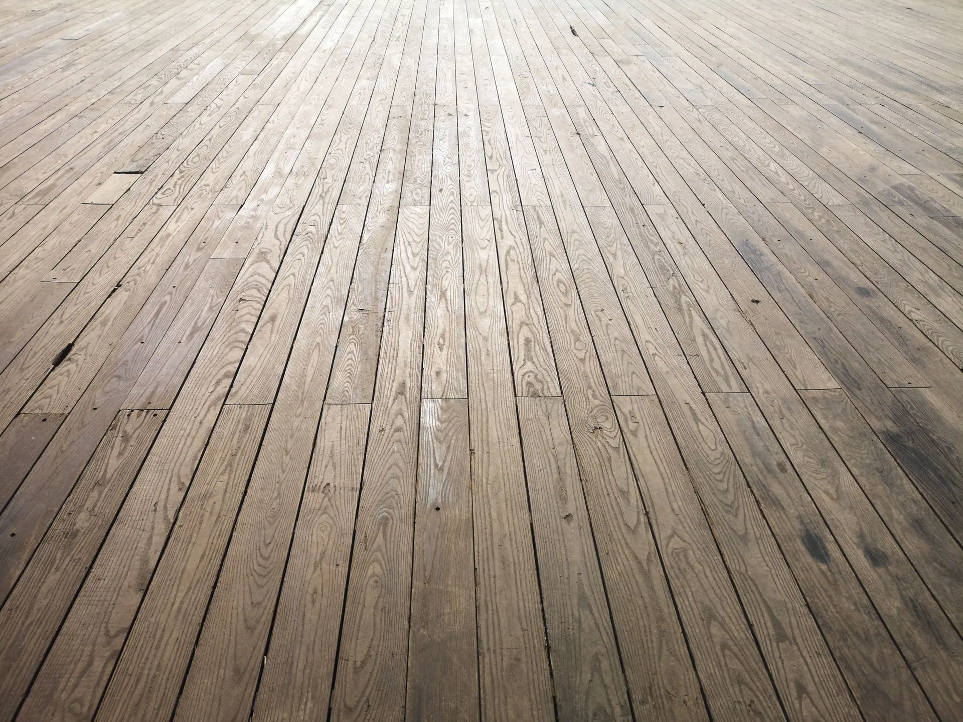 Wide view of a long run of aged wood floor planks