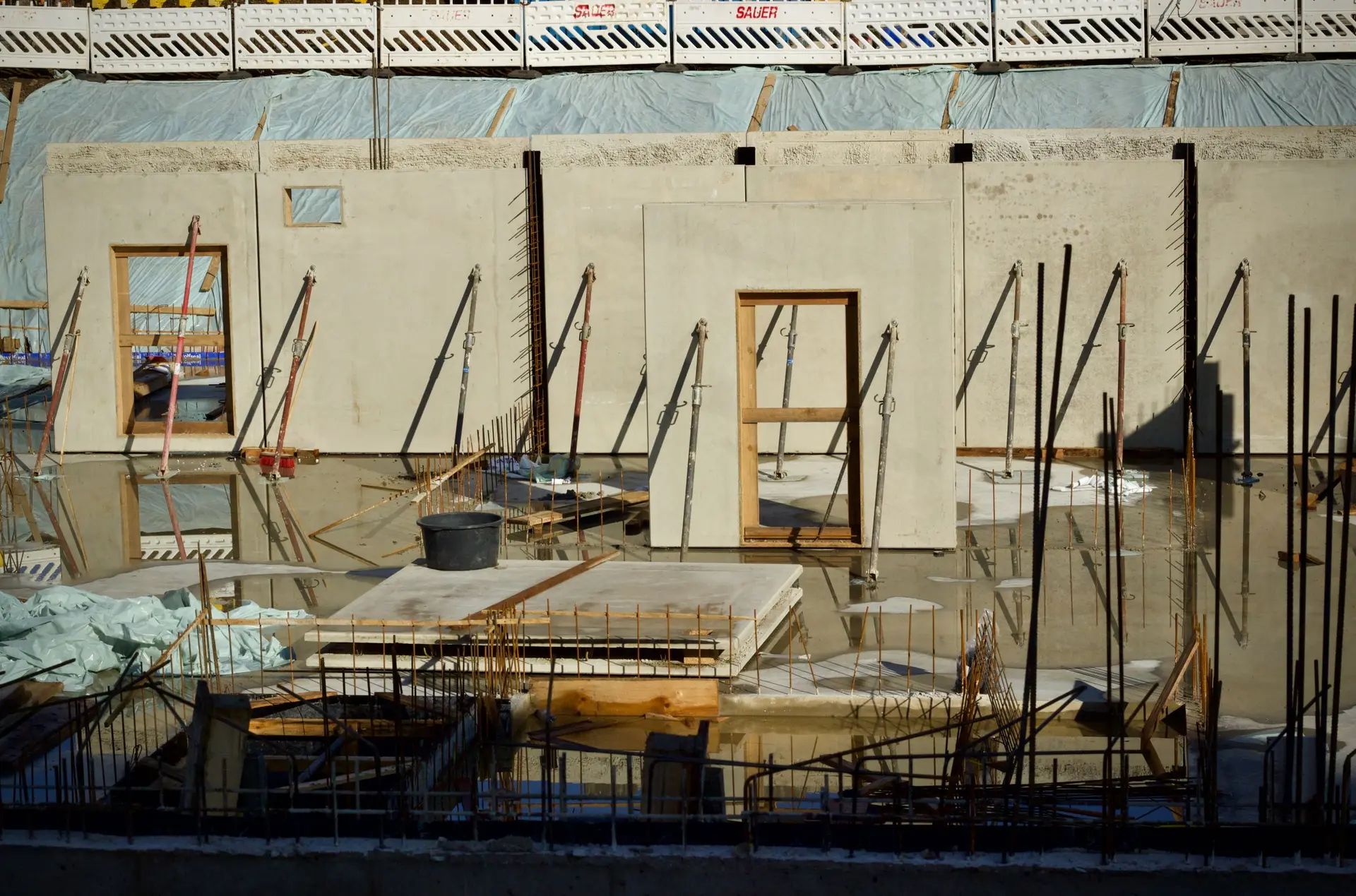 Poured concrete walls with window and door bucks at a construction site