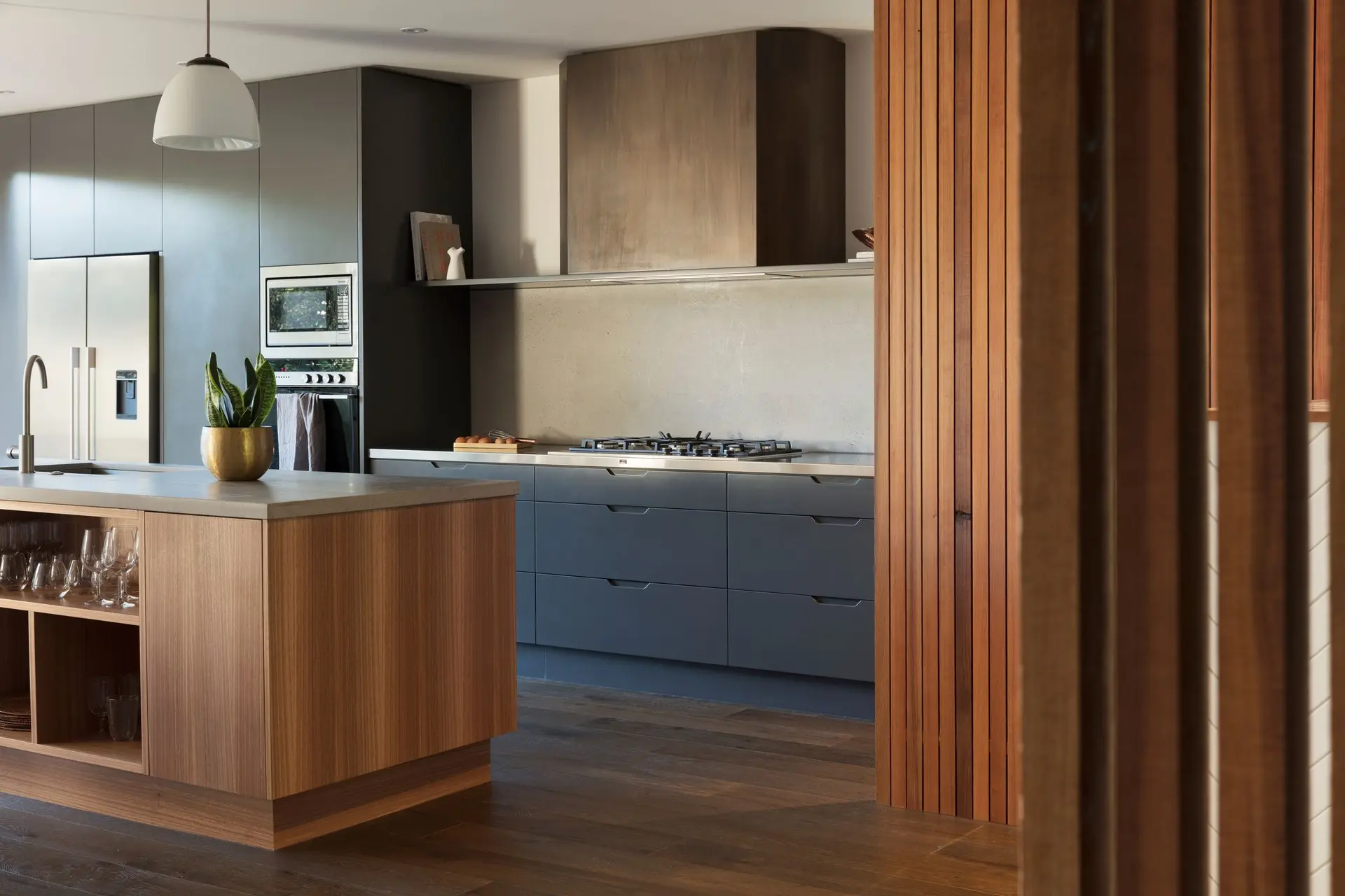 Kitchen with a dark wood island, gray cabinets and a stainless range