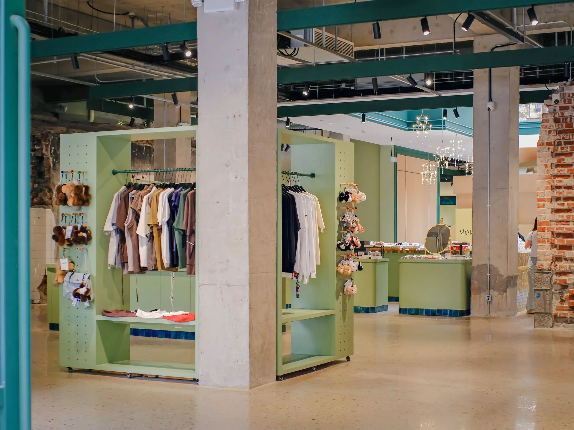 Store with pale green display shelving and hanging clothing
