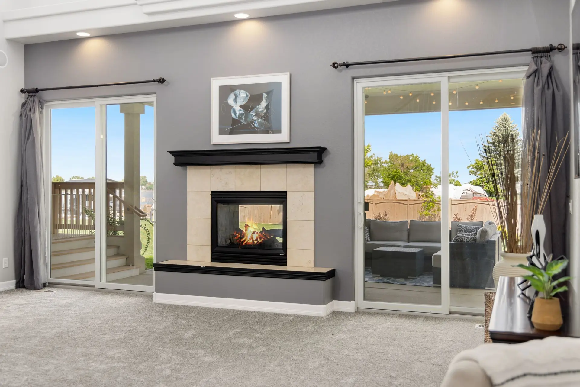 Living room with a fireplace between two sliding glass patio doors